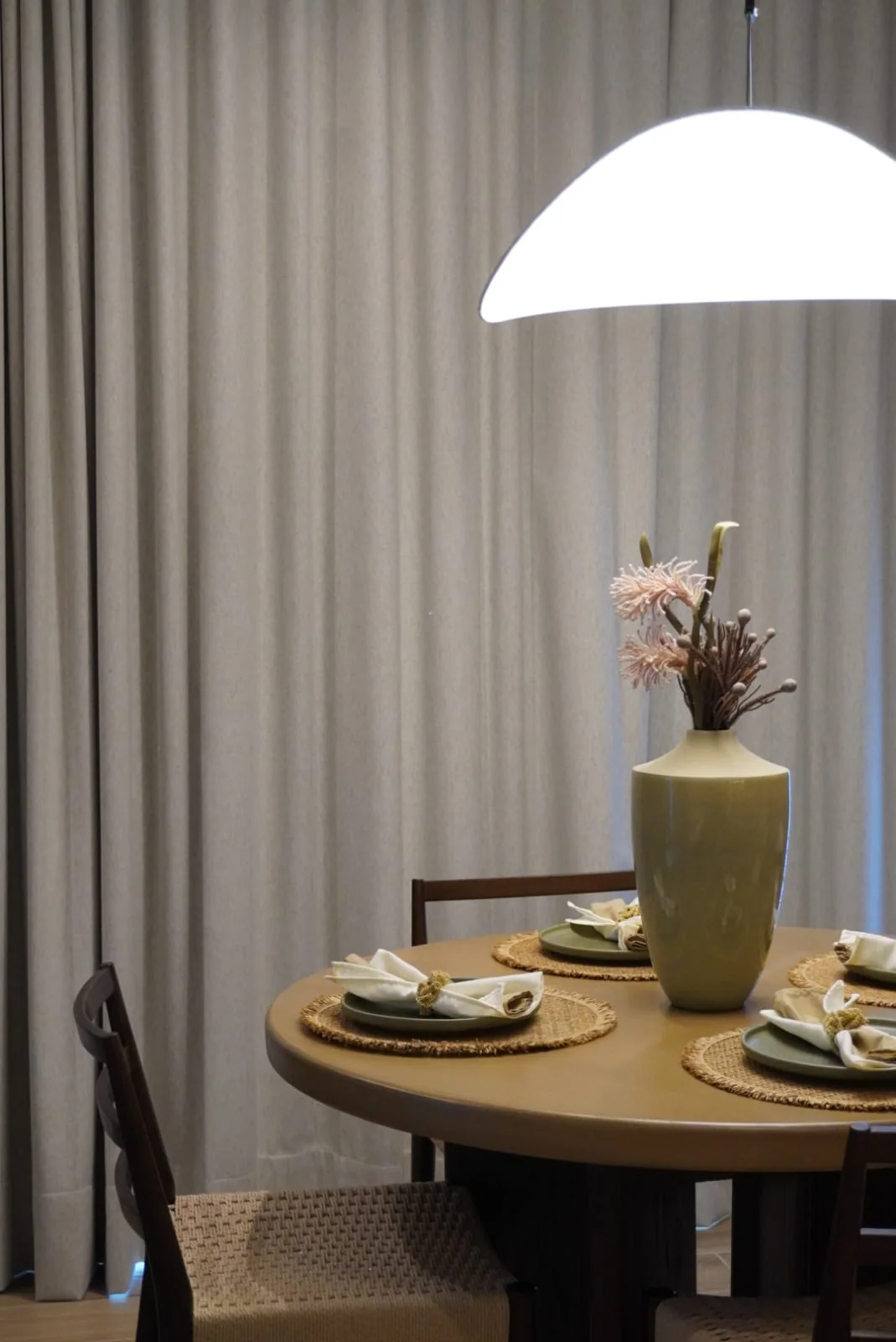 Comedor de SENCIA con lámpara escultórica, madera natural y mesa puesta.