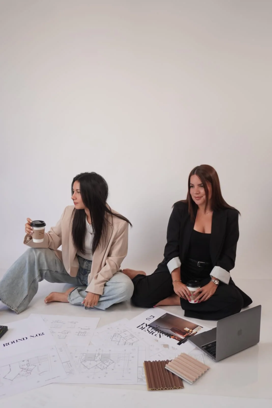 Las dos diseñadoras de SENCIA con planos y muestras de materiales